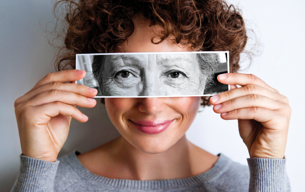 young-woman-holding-image-of-aging-woman-in-front-of-her.jpg